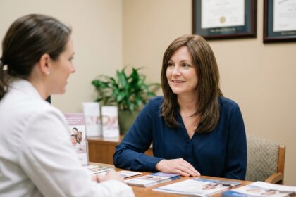 Femme portant une perruque médicale lors d'une consultation avec une professionnelle de santé dans un cabinet médical