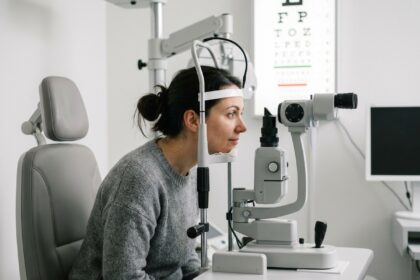 Femme passant un examen de la vue chez l'opticien, regardant dans une lampe à fente en salle d'examen optique