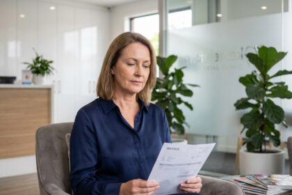 Femme d'âge moyen en blouse navy dans une salle d'attente moderne