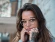 woman in blue sweater wearing eyeglasses