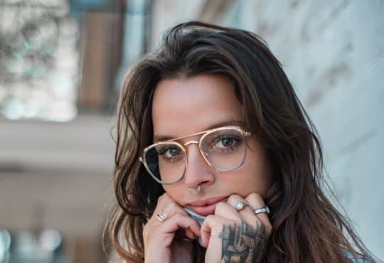 woman in blue sweater wearing eyeglasses